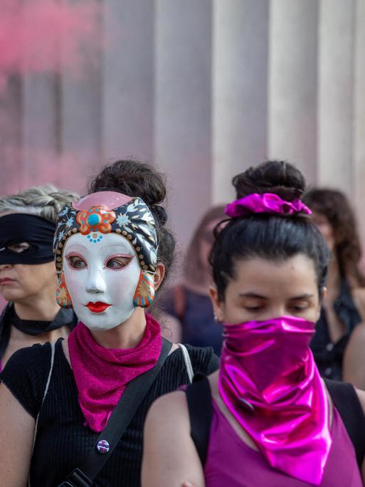 Aktivistinnen haben sich in Mailand versammelt: Sie sind mit lila Halstüchern maskiert oder tragen Masken. Es gibt auch lila Rauch. Es ist eine "Nicht-eine-Weniger"-Aktion gegen Femizide.