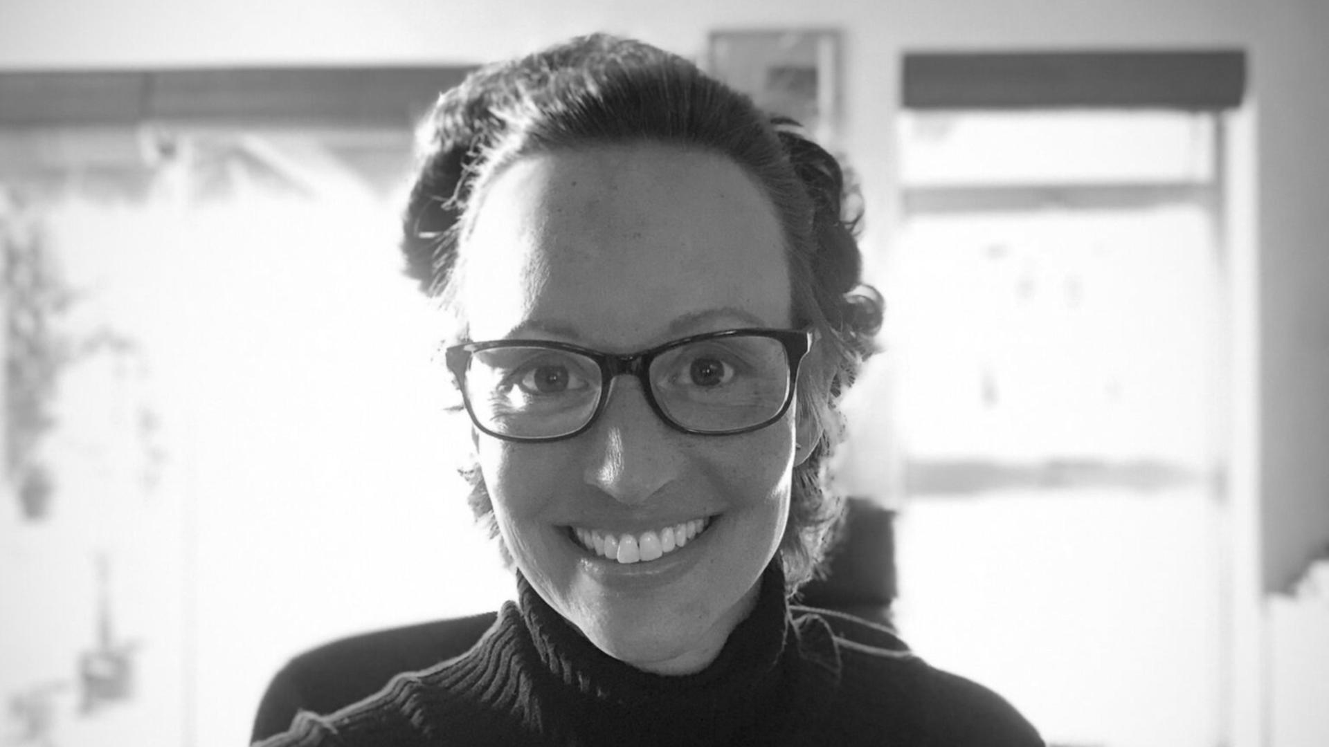 Schwarzweißaufnahme der 2022 verstorbenen schweizerischen Astrophysikerin Carolina Ödman-Govender, die freundlich in die Kamera lacht

