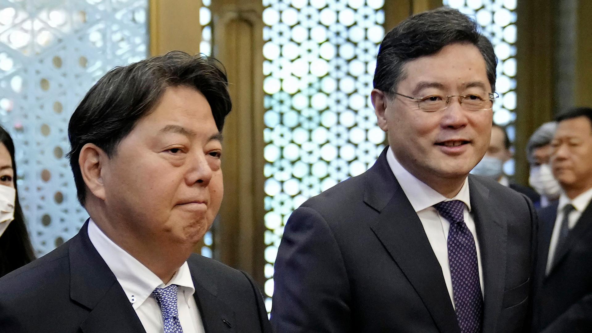 Die Außenminister Japans und Chinas stehen nebeneinander. Beide lächeln verhalten.