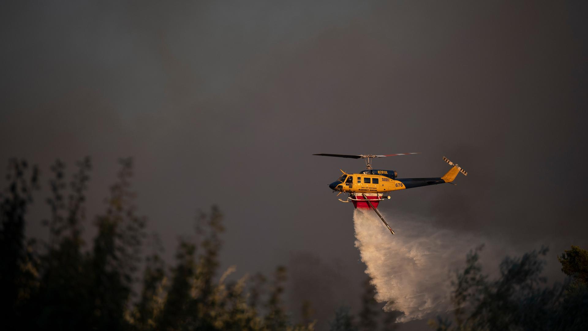 Ein Hubschrauber wirft während eines Waldbrandes in Griechenland Wasser ab.