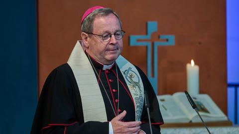 Vorsitzender der Deutschen Bischofskonferenz, Bischof Georg Bätzing bei einem ökumenischen Gottesdienst in der Berliner Getsemanekirche. Sein Blick geht nach unten, die Hände sind vor dem Körper verschränkt.