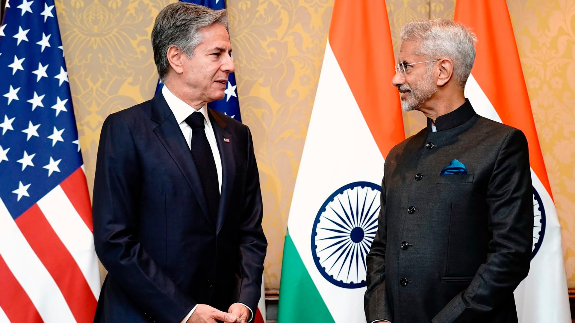US-Außenminister Blinken und sein indischer Kollege Jaishankar stehen sich gegenüber. Hinter ihnen die Landesfahnen.
