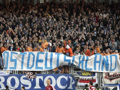 Fans von Hansa Rostock präsentieren ein Banner mit der Aufschrift "Ostdeutschland".