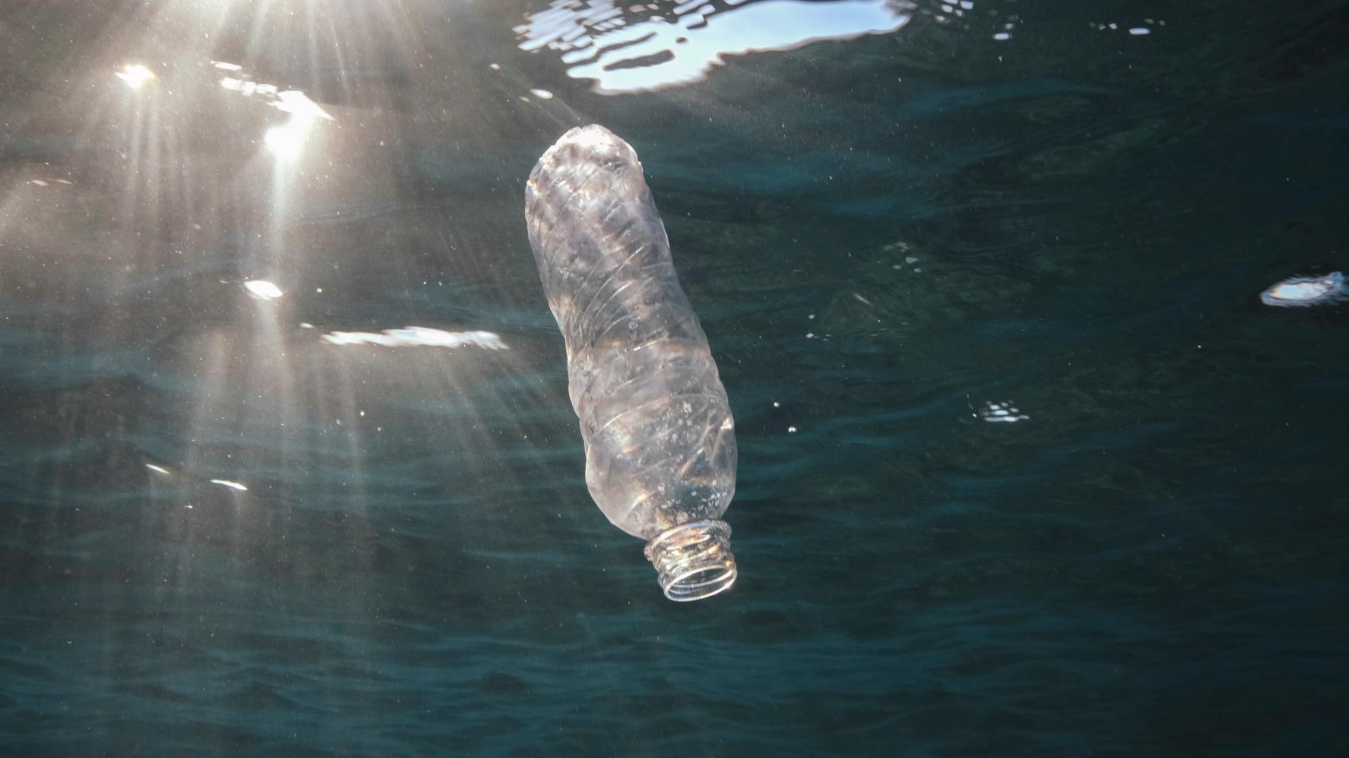 Eine Plastikflasche treibt im Meer