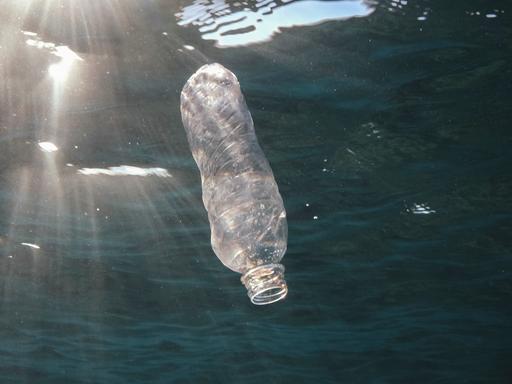 Eine Plastikflasche treibt im Meer