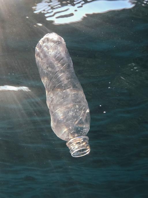 Eine Plastikflasche treibt im Meer