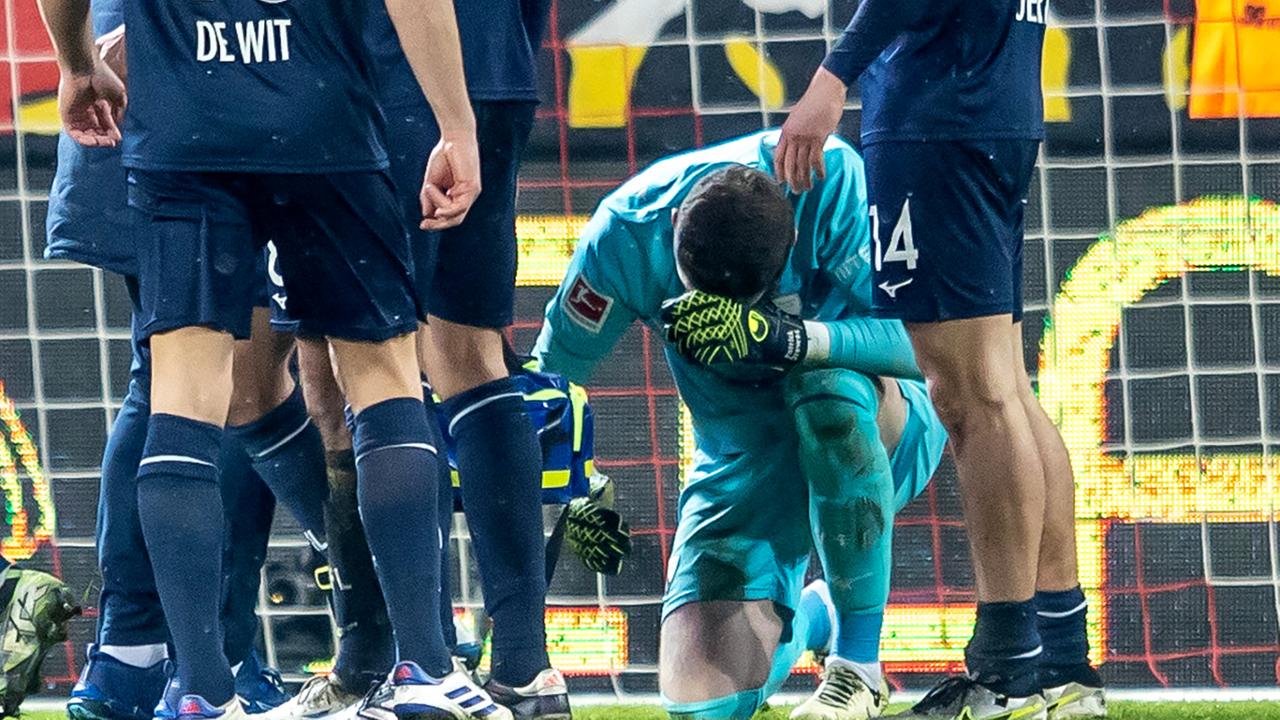 Torwart Patrick Drewes vom VfL Bochum kniet am Boden, nachdem er mit einem Gegenstand am Kopf getroffen wurde.