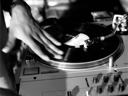 Hand eines DJs auf einem Plattenteller beim Scratching.