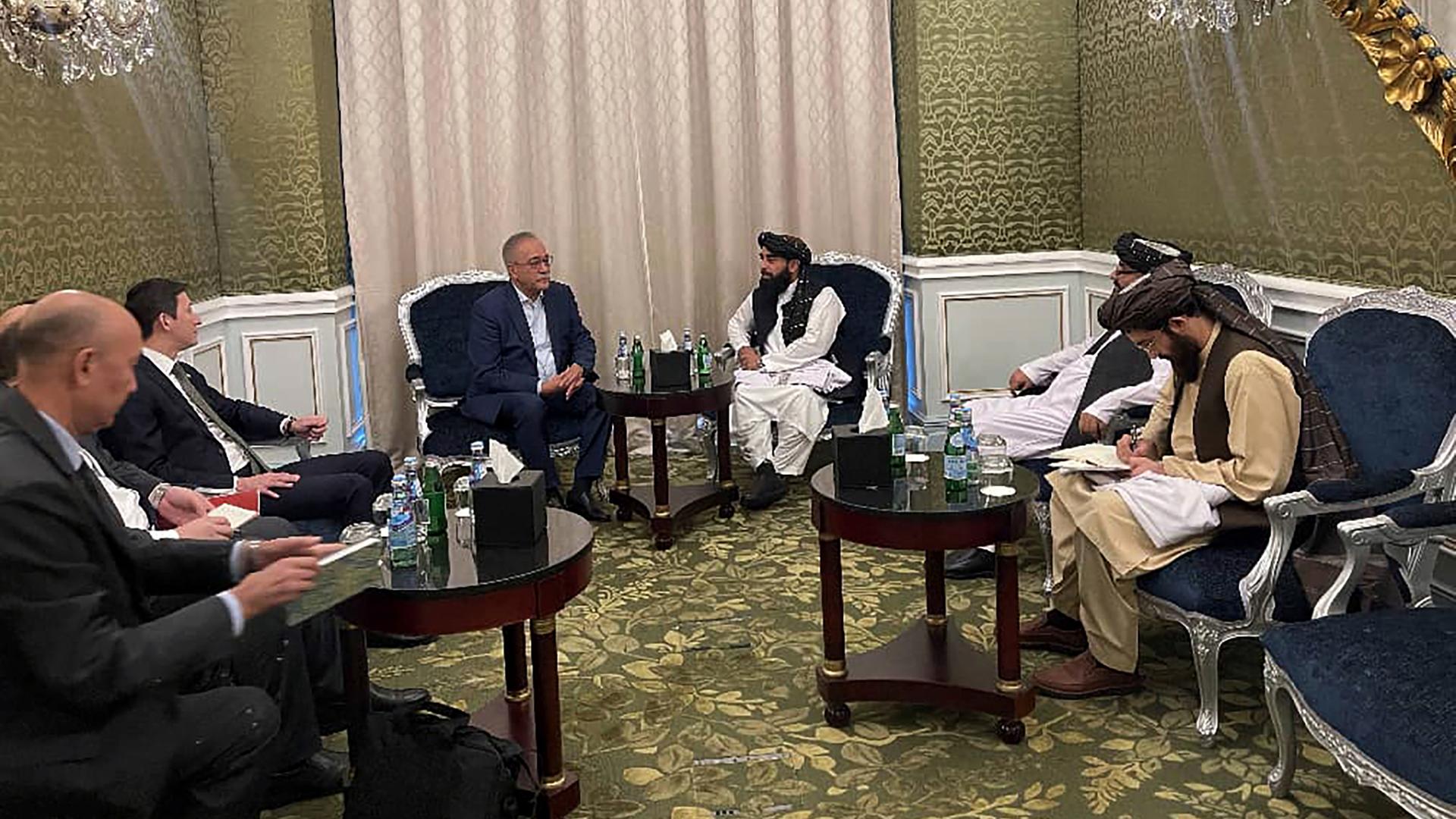 In einem Hotelzimmer sitzen Vertreter der Taliban und ein Gesandter Usbekistans. 