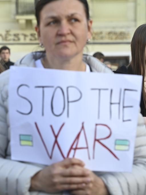 Besucherinnen und Besucher eines Solidaritätskonzerts mit der Ukraine, das Ende März von Warschau/ Polen nach Prag/Tschechien gestreamt wurde - eine Zuhörerin hält ein Schild mit der Aufschrift "Stop War" in der Hand