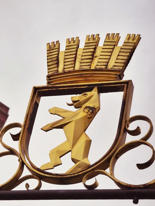 Das vergoldete Stadtwappen von Berlin mit dem Bären und einer Krone ist vor dem Roten Rathaus zu sehen.
