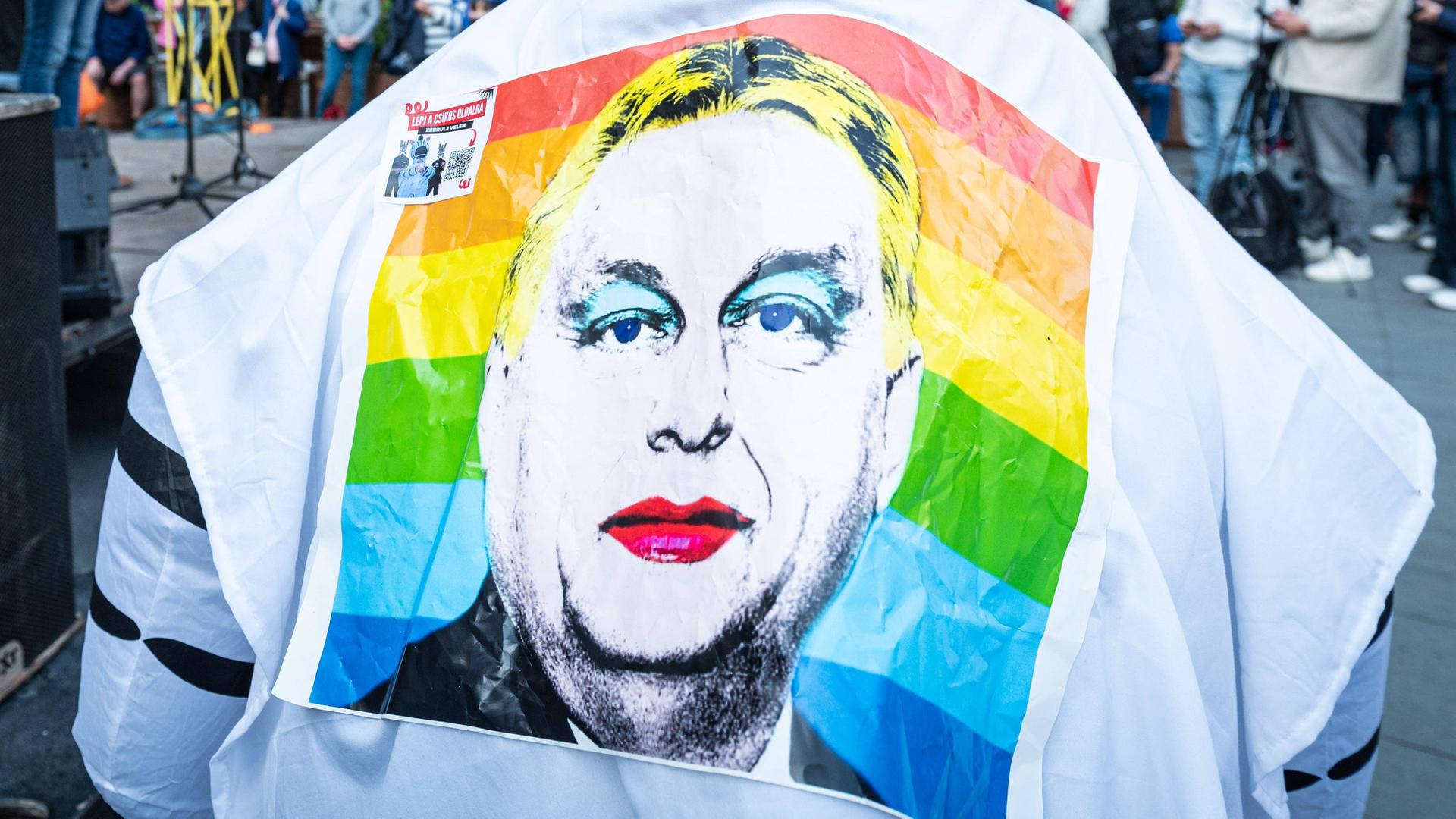 Ein Demonstrant in Budapest trägt eine Shirt, auf dessen Rücken Viktor Orbán in Regenbogenfarben zu sehen ist. Ein Demonstrant in Budapest trägt eine Shirt, auf dessen Rücken Viktor Orbán in Regenbogenfarben zu sehen ist.