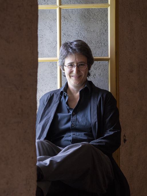 Die Schweizer Autorin Annette Hug sitzt in einem Fenstervorsprung. 