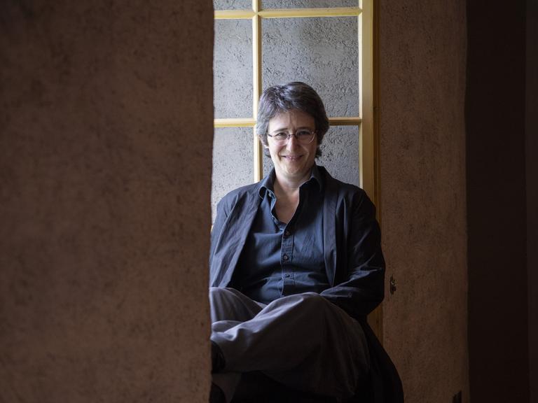 Die Schweizer Autorin Annette Hug sitzt in einem Fenstervorsprung. 