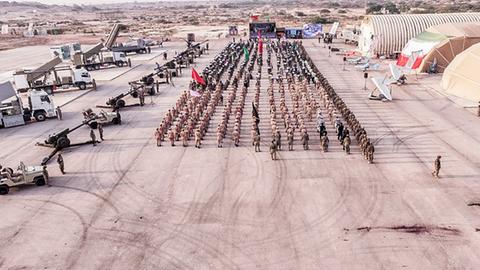 Soldaten der iranischen Revolutonsgarden stehen aufgereiht auf einem Platz, daneben stehen militärische Fahrzeuge und Geräte.