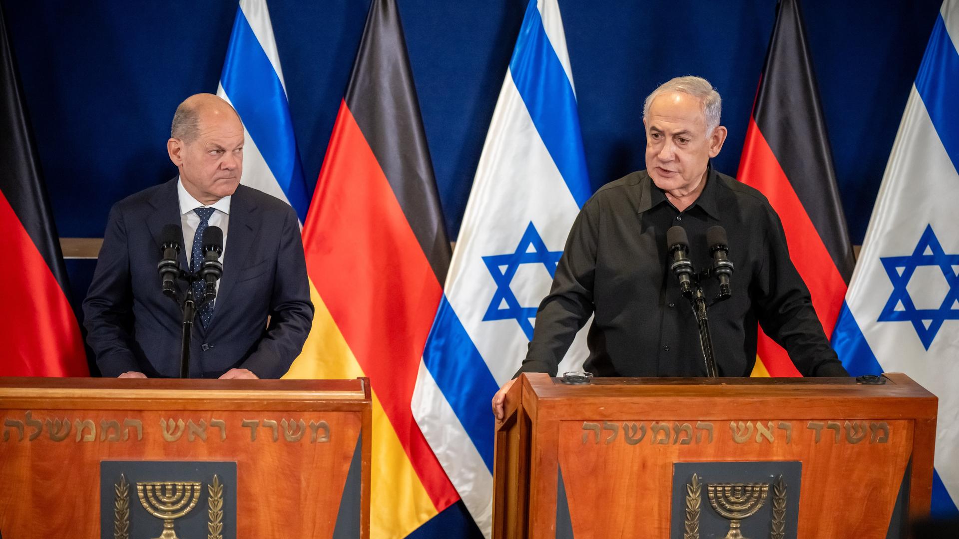 Bundeskanzler Olaf Scholz (SPD) nimmt neben Benjamin Netanjahu (r), Ministerpräsident von Israel, an einer Pressebegegnung nach dem Gespräch der beiden regierungschefs teil. Im Hintergrund die Flaggen der Bundesrepublik und Israels.