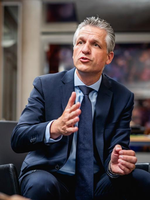 Thorsten Frei, Fraktionsvorsitzender der CDU/CSU-Fraktion, sitzt in einem schwarzen Stuhl und beugt sich nach vorne.