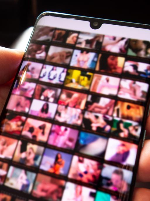 Pornografische Bilder sind unscharf auf dem Bildschirm eines Smartphones zu sehen (Symbolbild)