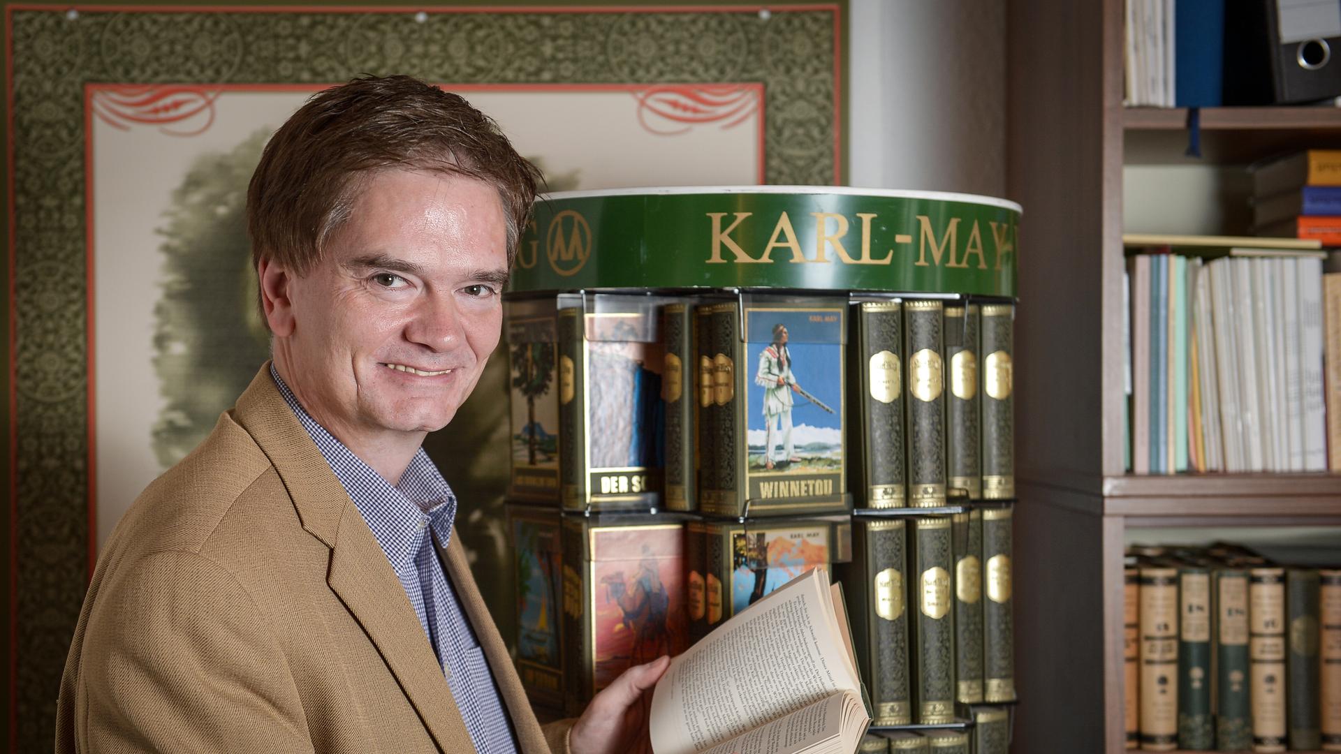 Bernhard Schmid, Chef des Bamberger Karl-May-Verlags, blättert am 25.06.2013 in seinem Büro in Bamberg (Bayern) in einem Winnetou-Buch. Der Verlag wurde am 1. Juli 1913 gegründet und konzentriert sich bis heute allein auf Karl May (1842-1912). 