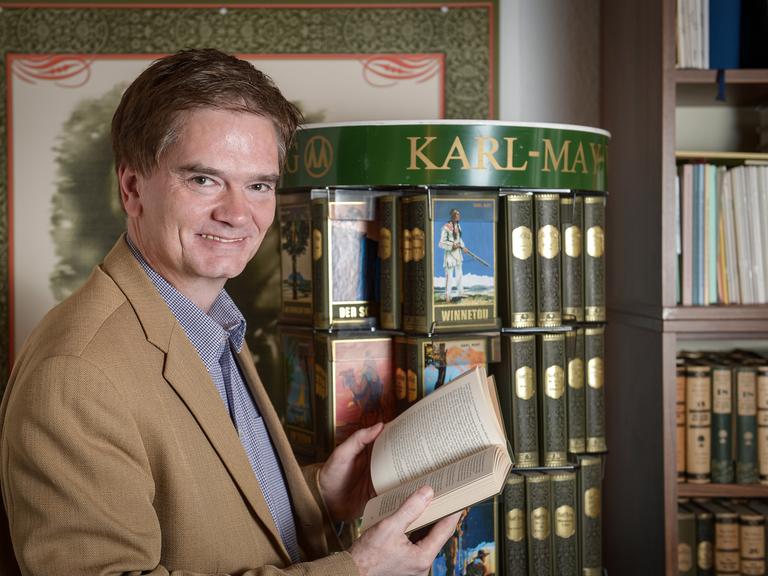 Bernhard Schmid, Chef des Bamberger Karl-May-Verlags, blättert am 25.06.2013 in seinem Büro in Bamberg (Bayern) in einem Winnetou-Buch. Der Verlag wurde am 1. Juli 1913 gegründet und konzentriert sich bis heute allein auf Karl May (1842-1912). 