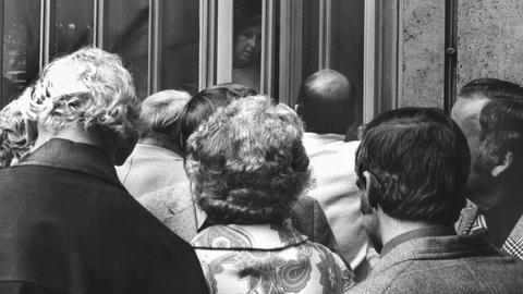Historisches Schwarzweißfoto von Sparern, die vor dem geschlossenen Eingang der Herstatt-Bank stehen.