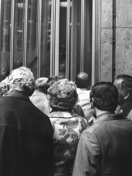 Historisches Schwarzweißfoto von Sparern, die vor dem geschlossenen Eingang der Herstatt-Bank stehen.