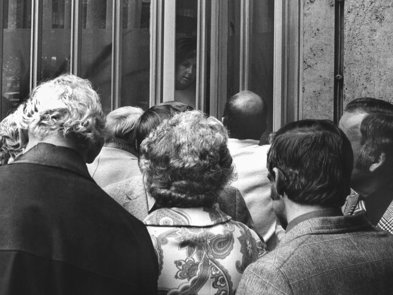 Historisches Schwarzweißfoto von Sparern, die vor dem geschlossenen Eingang der Herstatt-Bank stehen.
