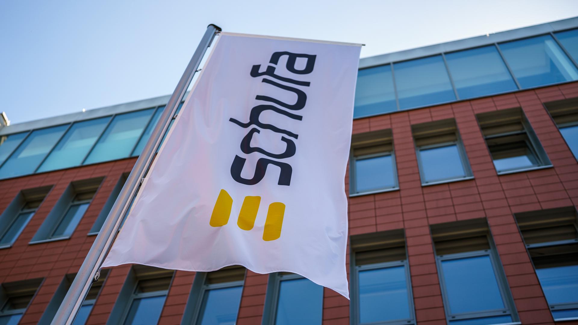 Eine Flagge mit dem Firmenlogo flattert vor dem  Geschäftssitz der Schufa in Wiesbaden. 