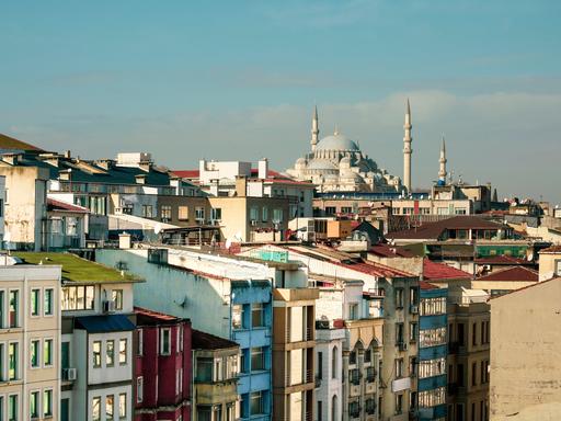 Ein Meer von windschiefen, bunten und eng nebeneinanderstehenden Häusern. Im Hintergrund die Süleymaniye Moschee.