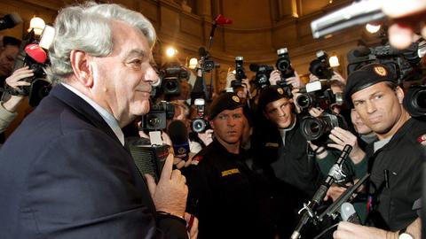 Der Brite David Irving steht umrundet von Fotografen und Kamerateams in einem Wiener Gerichtssaal. Er lächelt. 