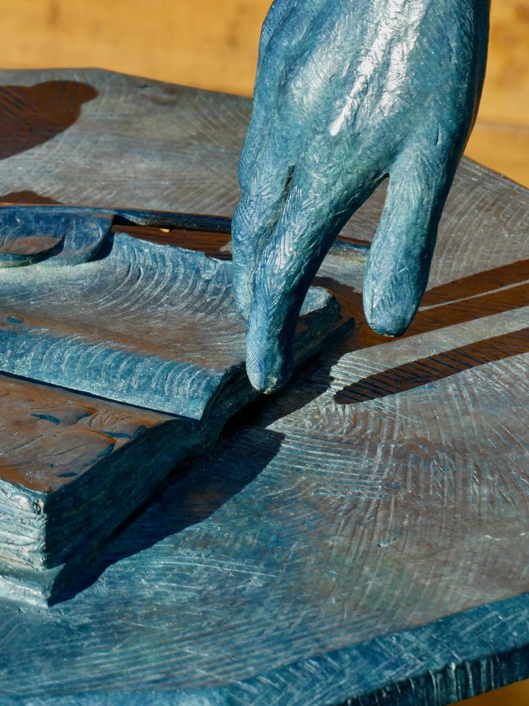 Das Detail einer Skulptur der Schriftstellerin Jane Austen zeigt eine Hand mit aufgeschlagenem Buch, Feder und Tintenfass. Das Detail einer Skulptur der Schriftstellerin Jane Austen zeigt eine Hand mit aufgeschlagenem Buch, Feder und Tintenfass.