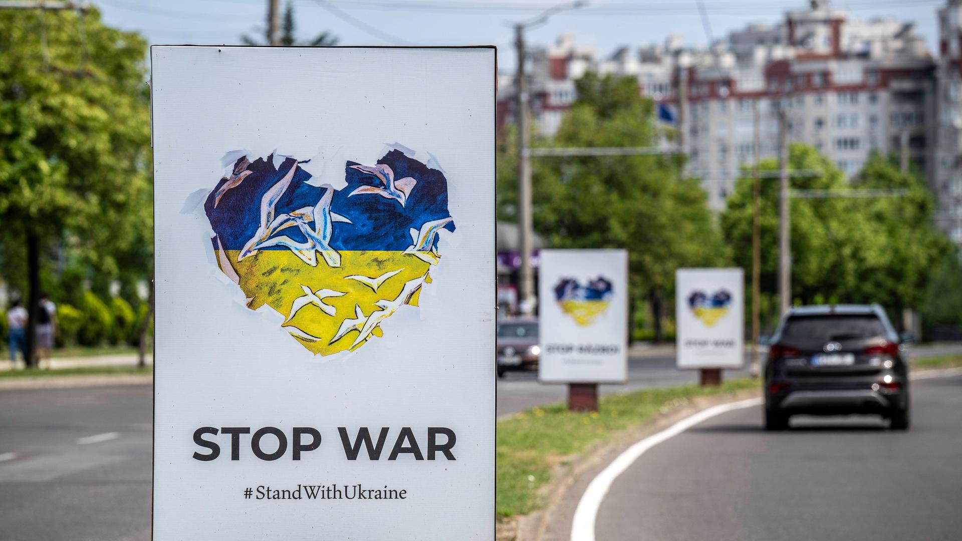 Eine Straße in Chisinau mit mehren Plakaten am Straßenrand, auf denen "Stop War" und ein Herz in den ukrainischen Nationalfarben zu sehen ist.