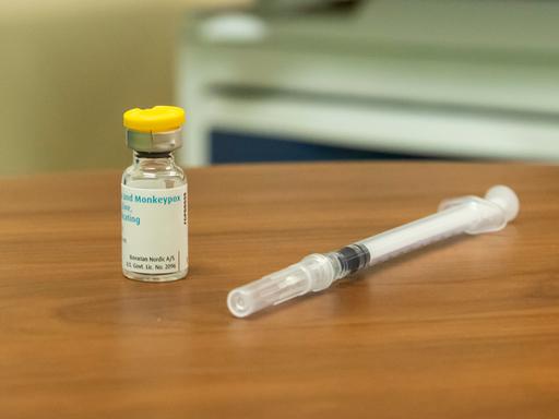 Mpox-Impfstoff und Spritze auf einem Holztisch