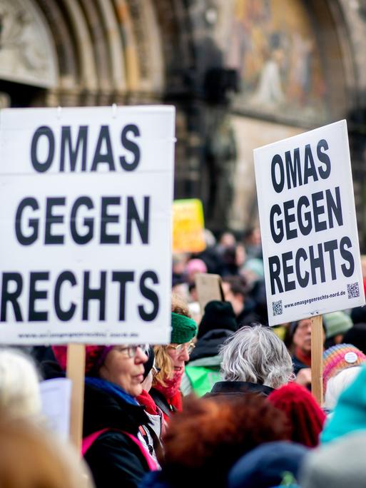 Zahlreiche Menschen stehen dicht gedrängt auf einer Demonstration. Mehrere Teilnehmer halten Schilder mit der Aufschrift "Omas gegen Rechts" hoch.