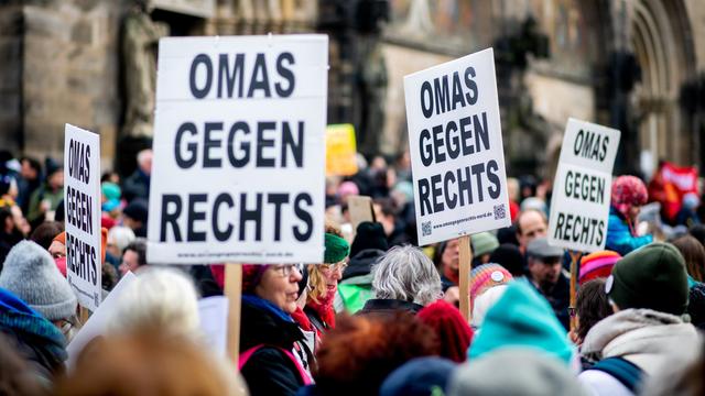 Zahlreiche Menschen stehen dicht gedrängt auf einer Demonstration. Mehrere Teilnehmer halten Schilder mit der Aufschrift "Omas gegen Rechts" hoch.