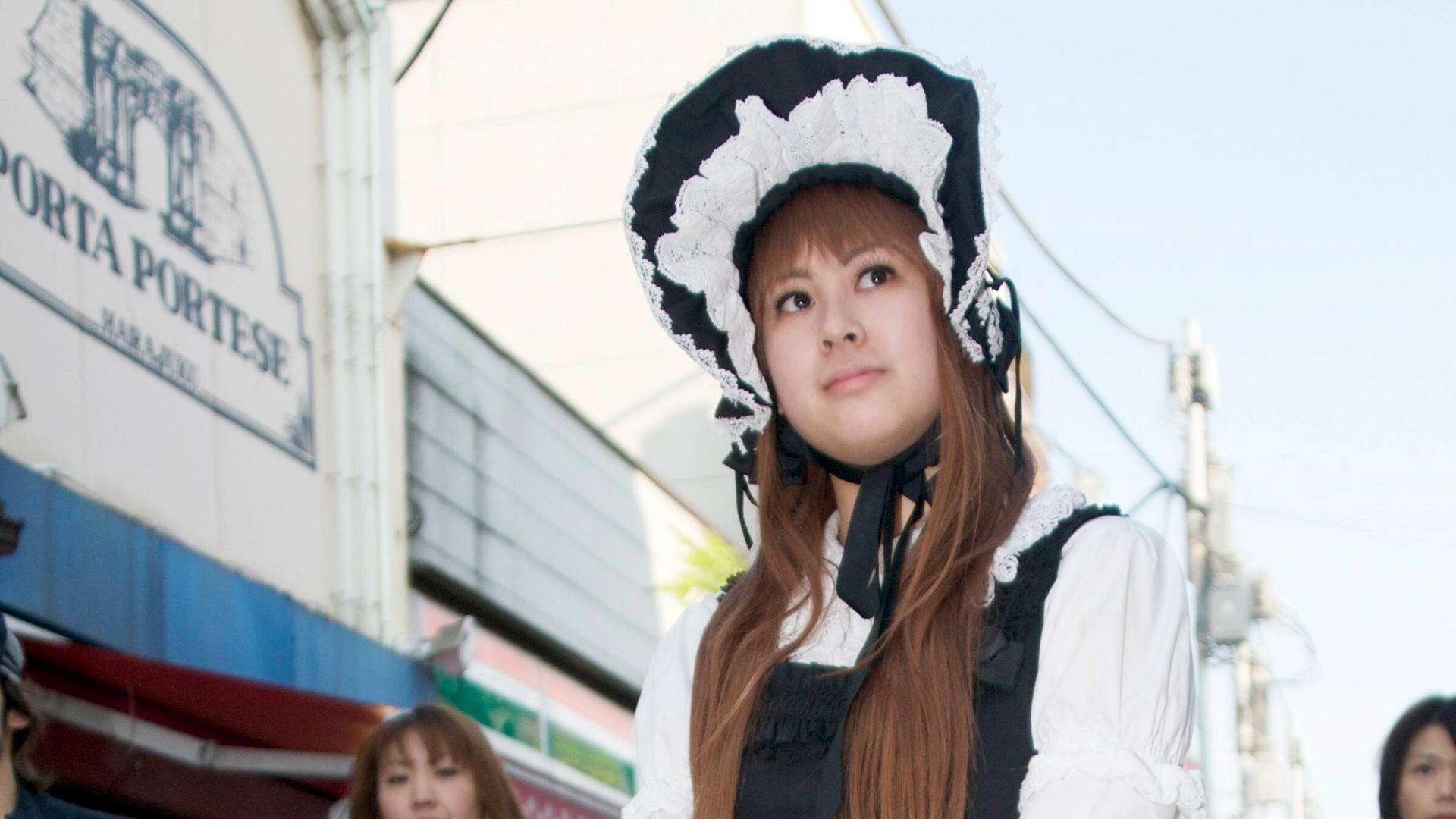 Eine junge Japanerin mit viktorianischem Spitzenhäubchen, Rüschenbluse in weiß und weiten Röcken in schwarz-rosa Eine junge Japanerin mit viktorianischem Spitzenhäubchen, Rüschenbluse in weiß und weiten Röcken in schwarz-rosa