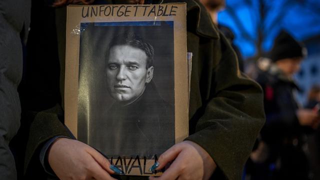 Die Händer einer Demonstrantin halten ein schild miot dem Foto von Alexej Nawalny in den Händen, worauf geschrieben steht: "Unforgettable" und "Nawalny"