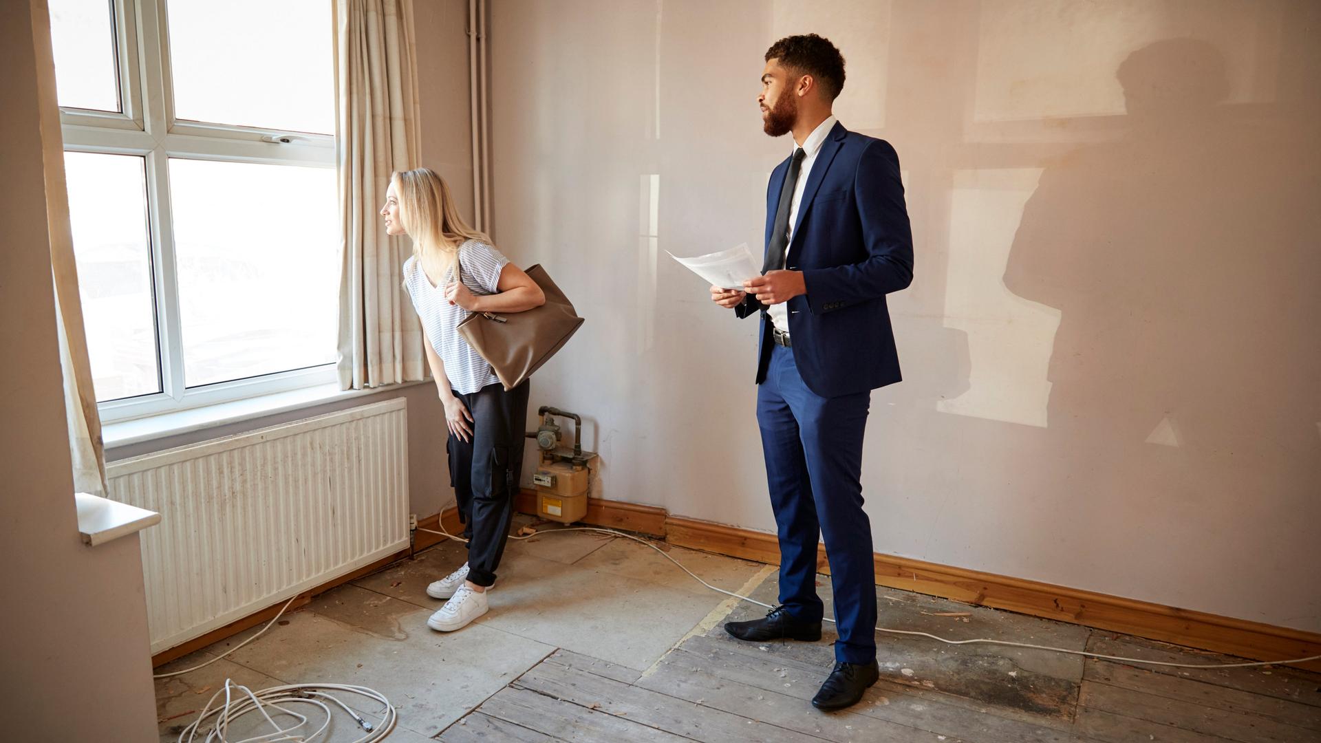 Immobilienmakler und eine Frau bei einer Wohnungsbesichtigung