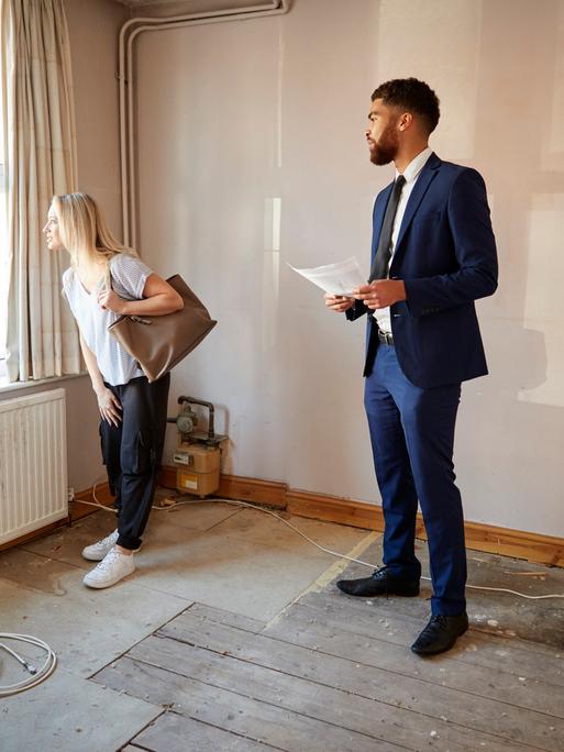 Immobilienmakler und eine Frau bei einer Wohnungsbesichtigung