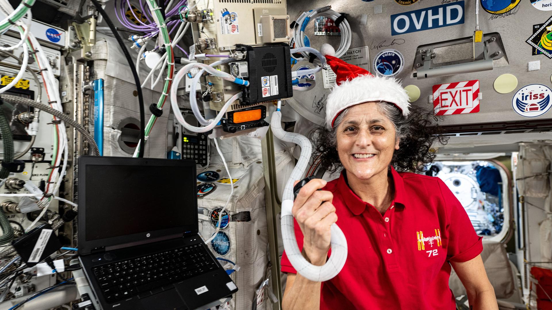 US-Astronautin Suni Williams neben technischen Geräten in der ISS mit Weihnachtsmütze auf dem Kopf. US-Astronautin Suni Williams neben technischen Geräten in der ISS mit Weihnachtsmütze auf dem Kopf.