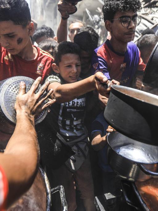 Gaza City am 18. Juni 2025: Einige Palästinenser erhalten warmes Essen von Hilfsorganisationen. Die Menschen leiden während des fortgesetzten Militäreinsatzes Israels Hunger.