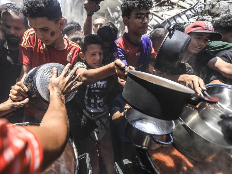 Gaza City am 18. Juni 2025: Einige Palästinenser erhalten warmes Essen von Hilfsorganisationen. Die Menschen leiden während des fortgesetzten Militäreinsatzes Israels Hunger.