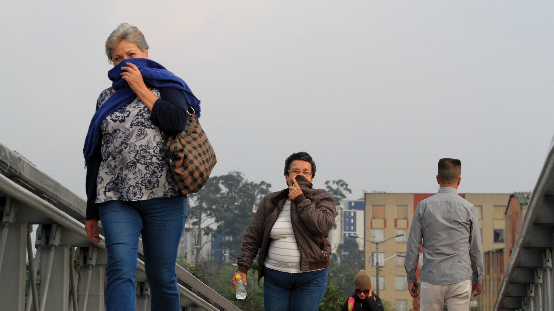 Menschen in Bogota halten sich ein Tuch vor den Mund aufgrund der Luftverschmutzung