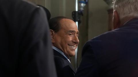 Silvio Berlusconi - lachend zwischen zwei weiteren Männern