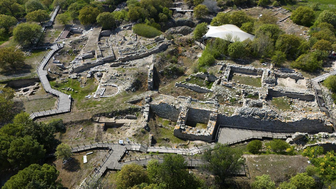 Eine Luftaufnahme historischer Ruinen mit alten Steinmauern eingebettet in üppige Vegetation, Troja