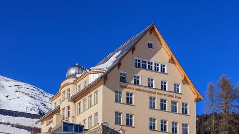 Das Physikalisch-Meteorologische Observatorium Davos in der Schweiz steht an einem Hang, auf dem Schnee liegt.