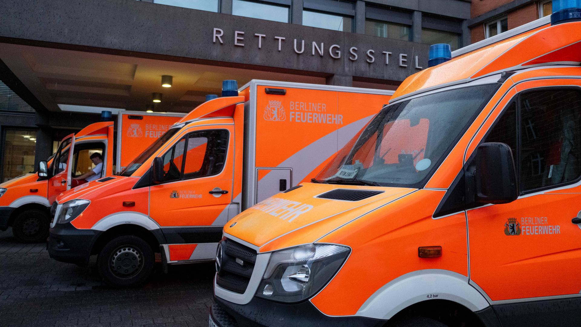 Drei Rettungswagen stehen vor einem Gebäude. Der Eingangsbereich ist zu sehen.