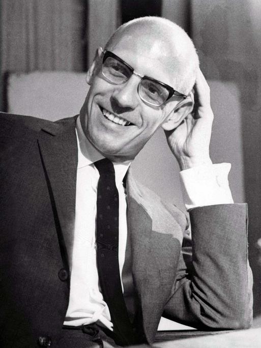 Schwarzweiß-Porträt von Michel Foucault an seinem Schreibtisch