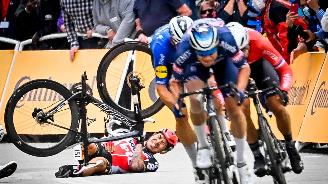 Zu sehen ist das Bild des Jahres 2021. Ein Radrennfahrer liegt auf dem Boden, während andere Fahrer an ihm vorbei sprinten. Zu sehen ist das Bild des Jahres 2021. Ein Radrennfahrer liegt auf dem Boden, während andere Fahrer an ihm vorbei sprinten.
