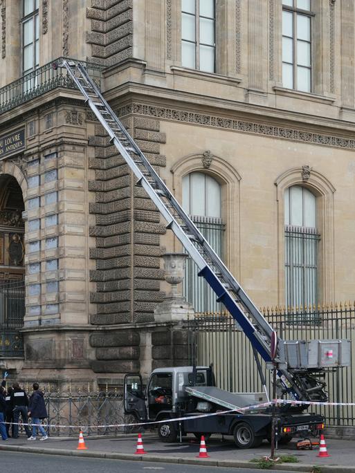 Französische Polizisten neben einem Möbelaufzug, der für den Raubüberfall auf das Museum Louvre in Paris verwendet wurde.